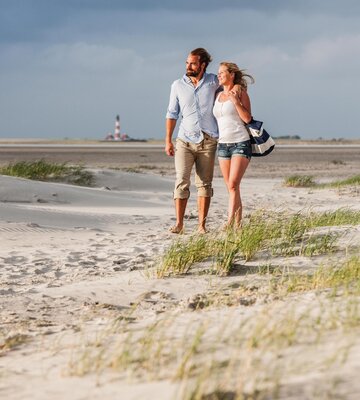 Spaziergang eines Paares am Strandabschnitt Ording Nord vor dem Westerhever Leuchtturm